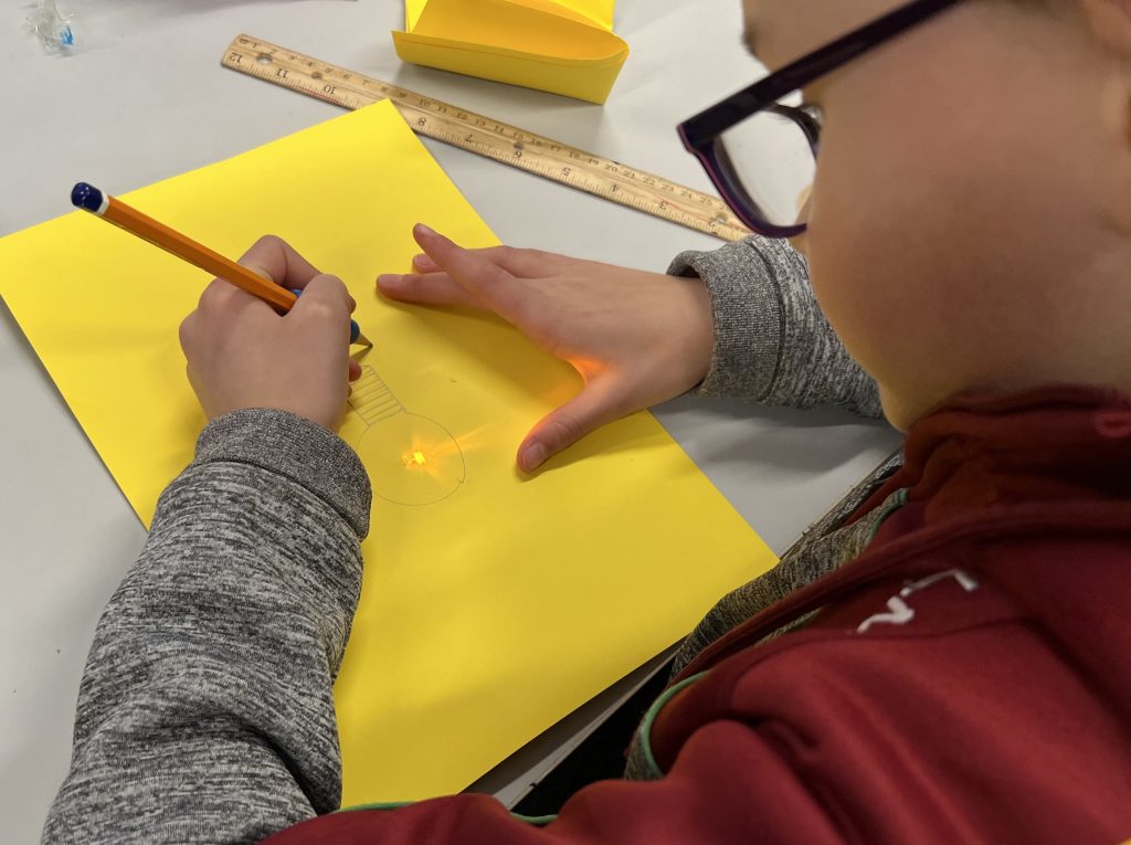 Student at Ardagh school designing an art work of a light bulb incorporating an LED