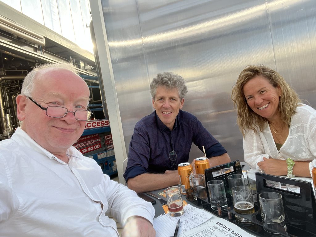 Me Peter Twining and Cathy sitting round a table with small glasses of beer for tasting.