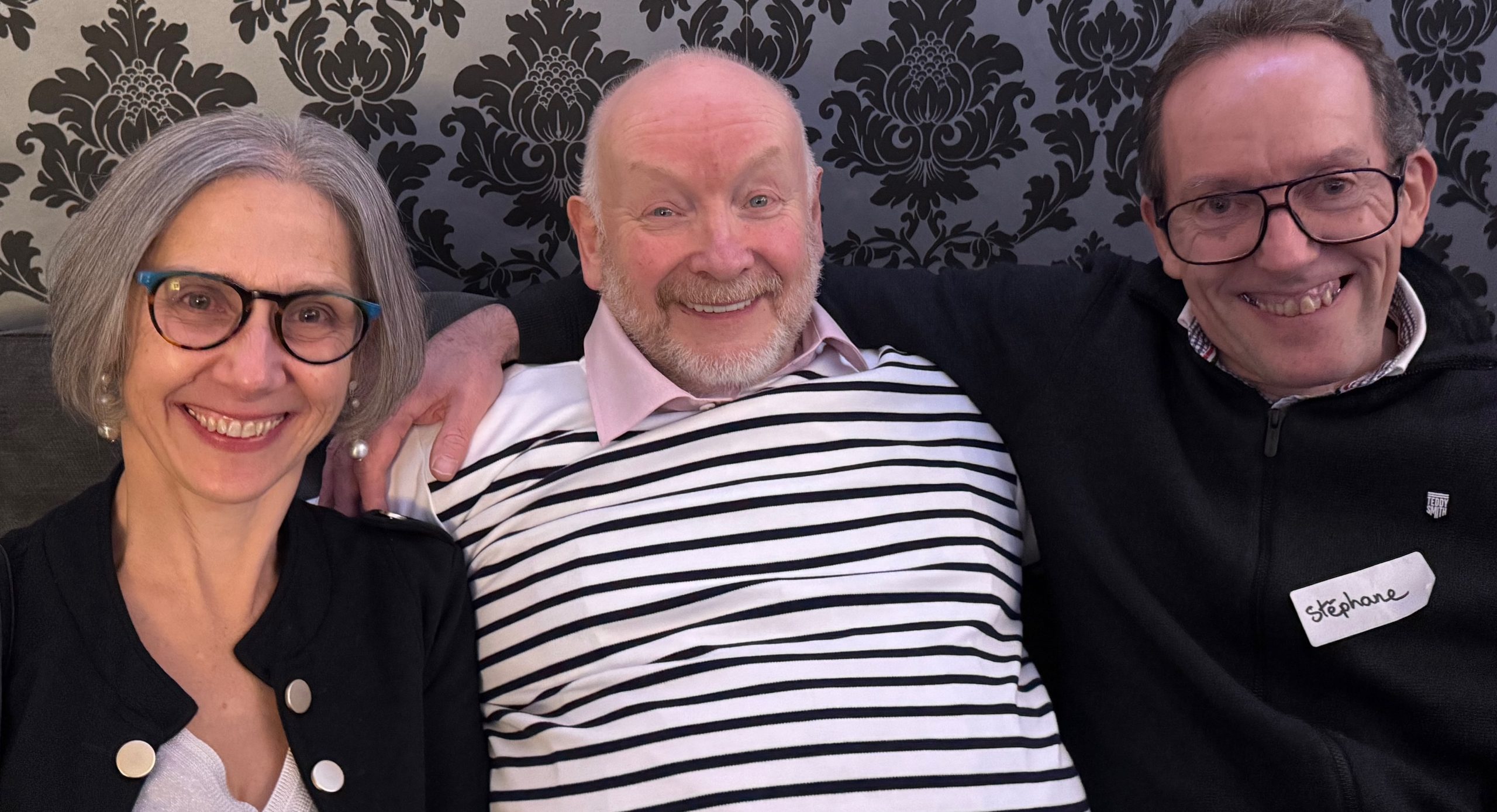 Three happy people - Isabelle, Richard and Stephane - sitting on a sofa.